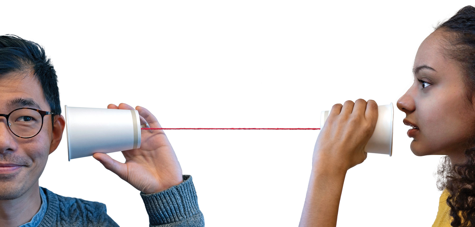 a man communicates with a women with paper cups connected by a string